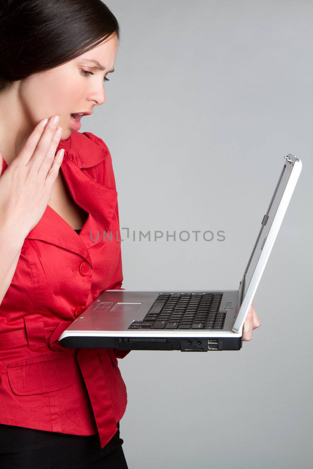Shocked woman holding laptop compuer