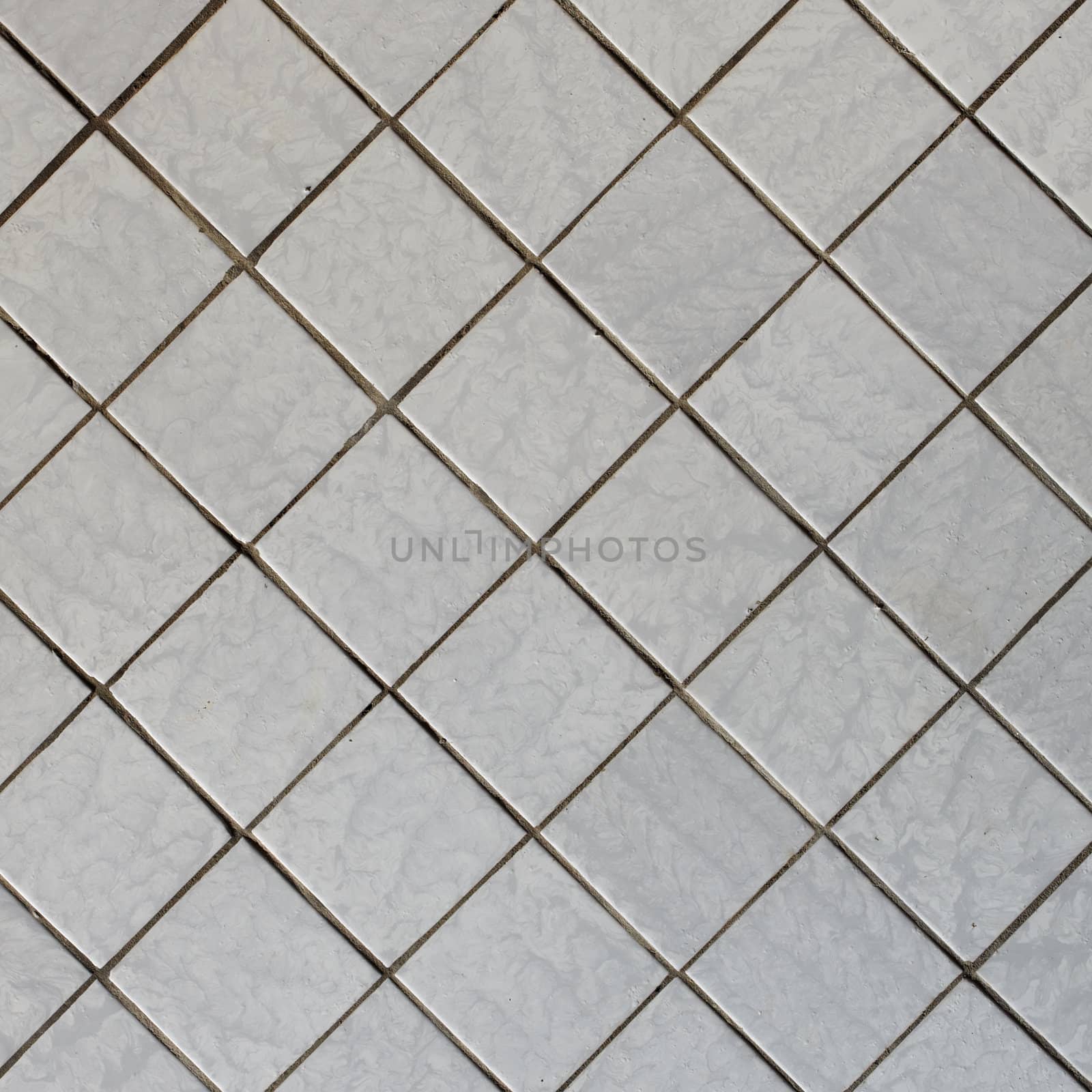 Wall covered with an old grey tile - a diagonal square texture