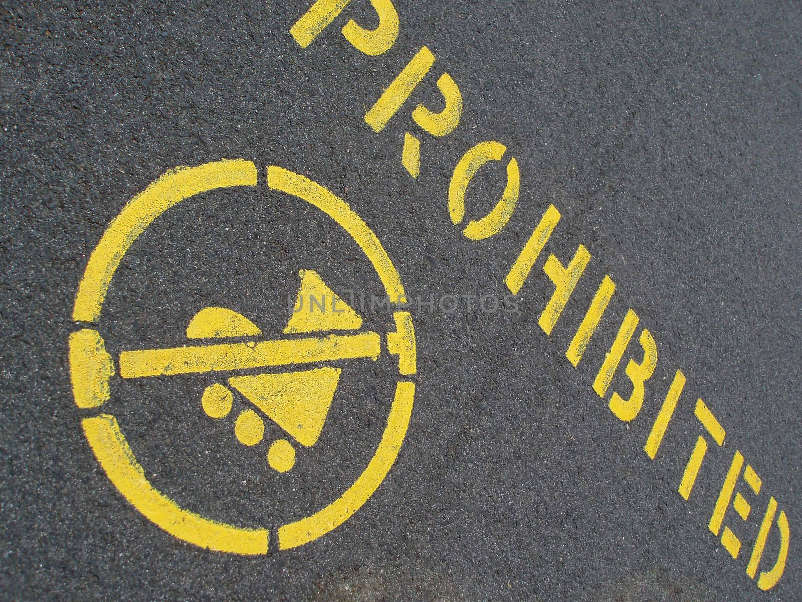 yellow painted pavement sign prohibiting inline skating