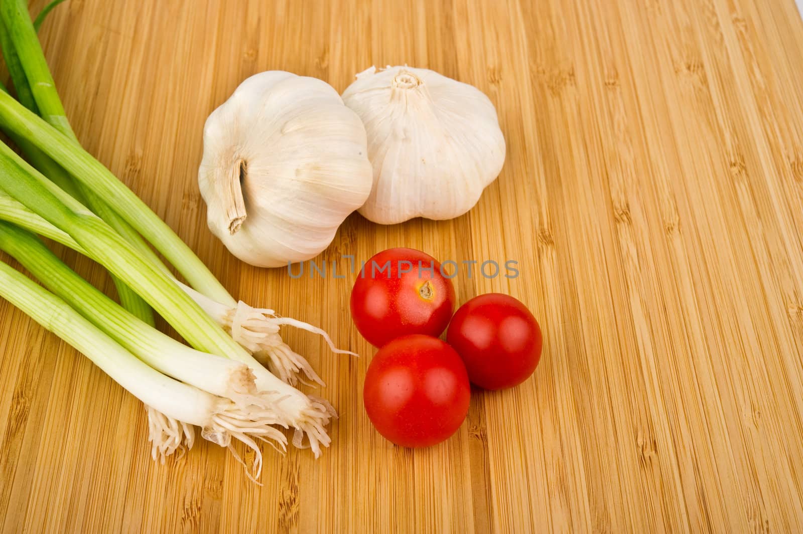 Image of Green Onions, Tomatoes, and Garlic on Cutting Board