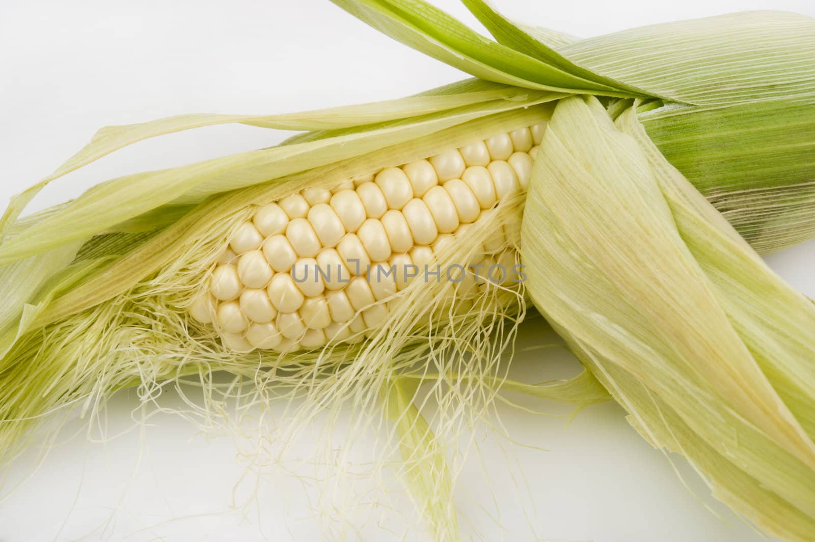 Close-up image of a partially shucked ear of corn
