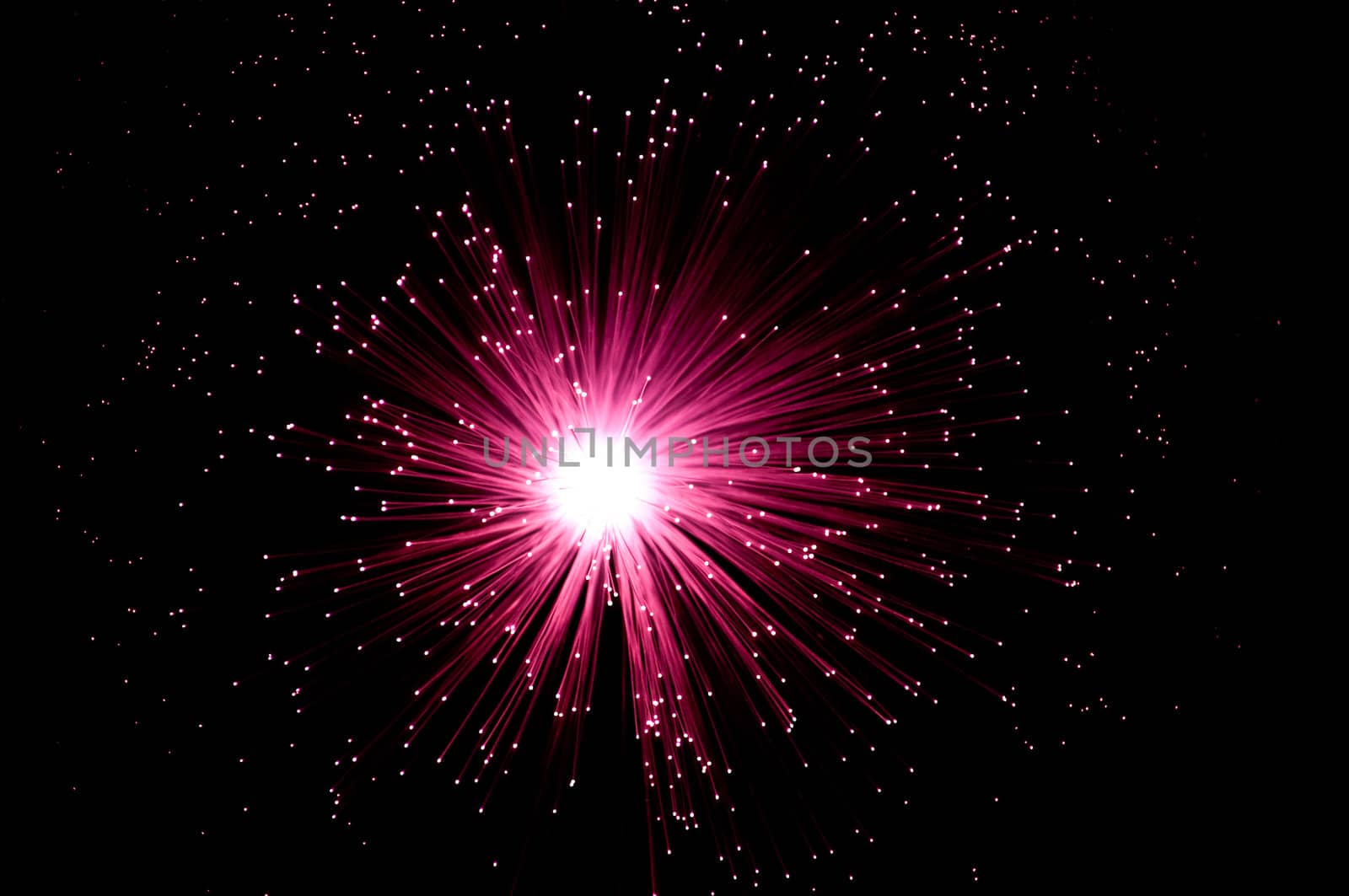 Overhead view capturing an illuminated red fibre optic light display arranged over black.