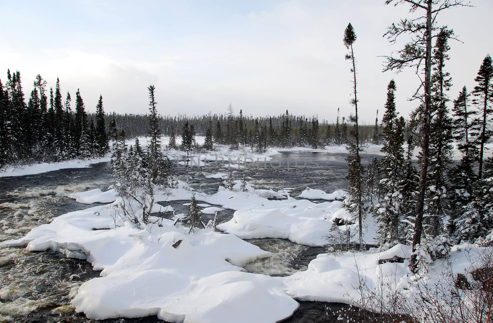 A northern river surrounded by snow on a cold day