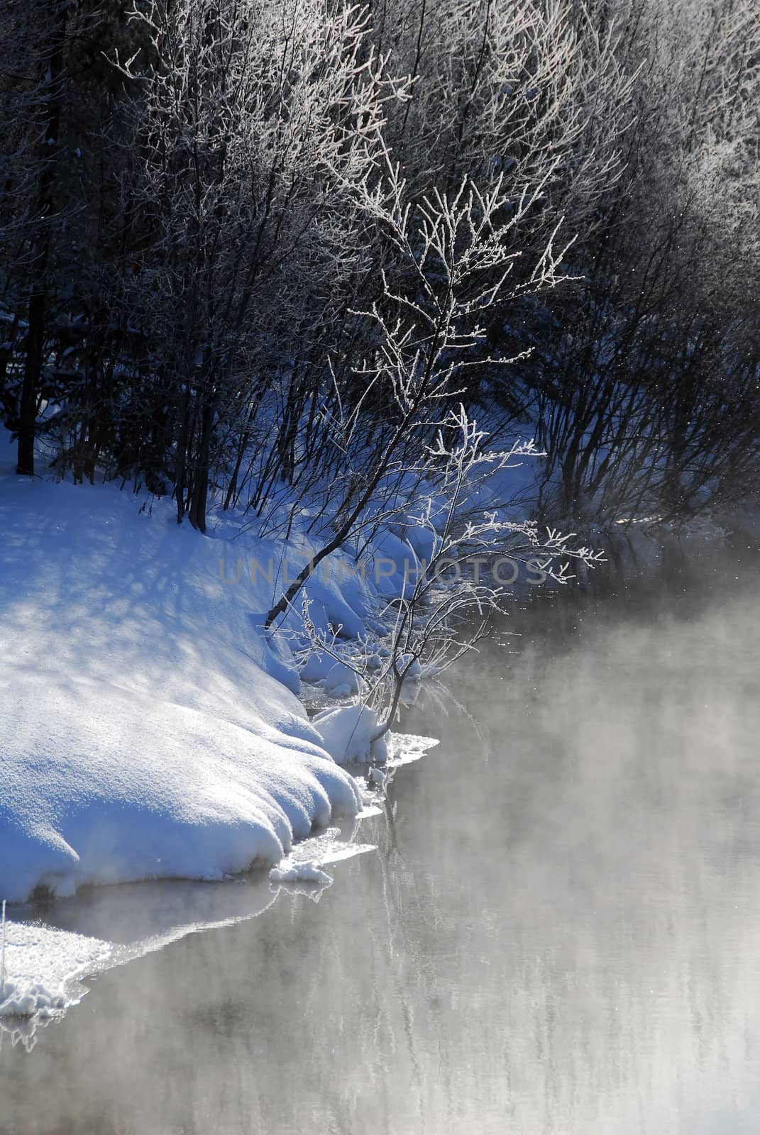 A winter landscape showing a foggy river on a cold day