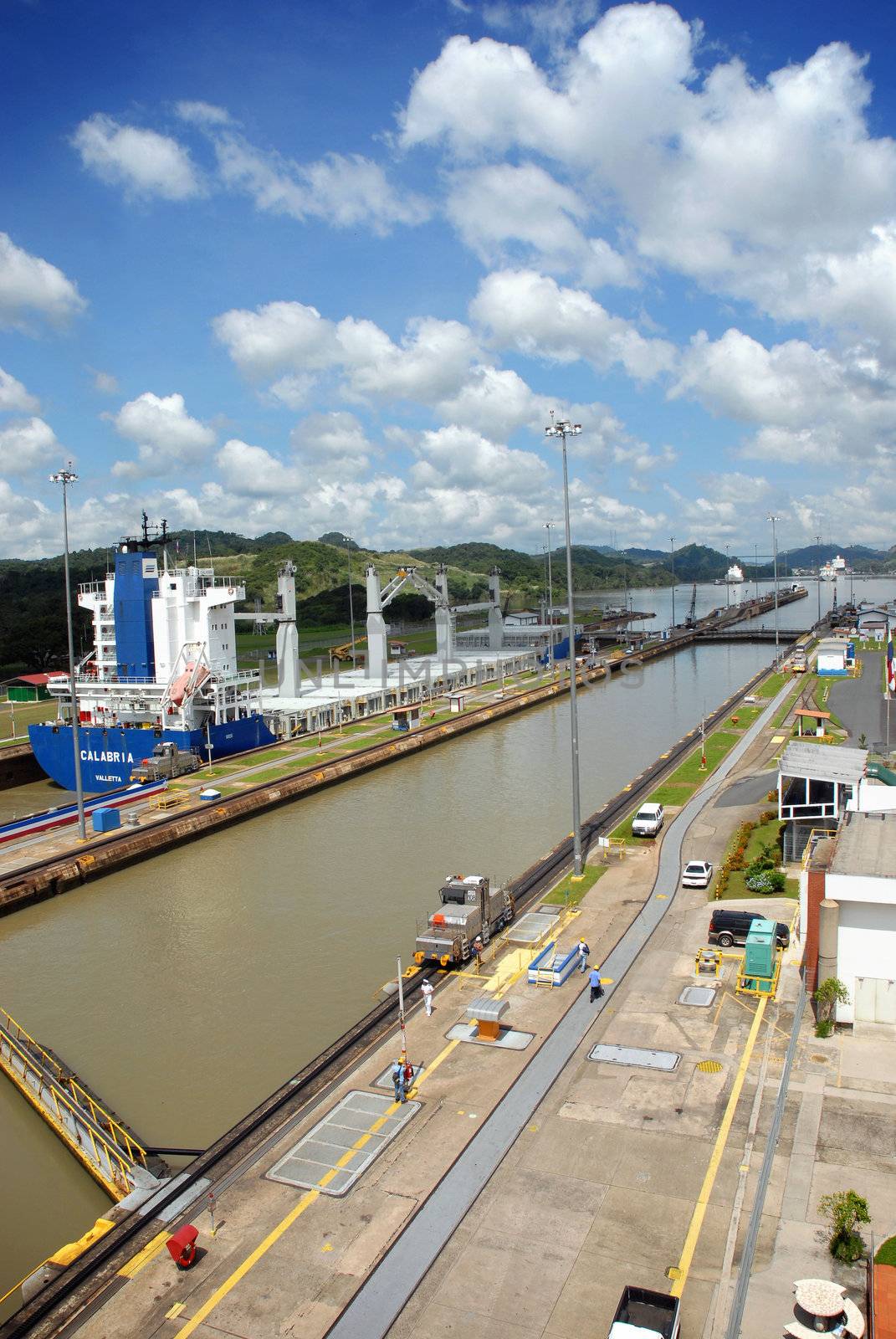 Panama Canal with a large container ship full of cargo in the background.