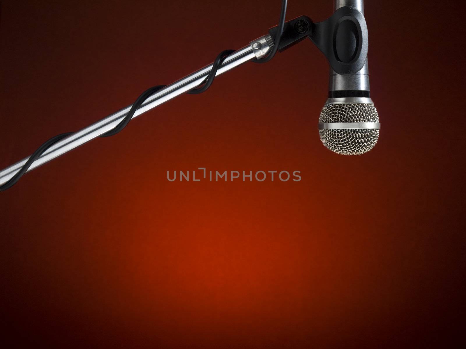 A microphone on a boom over a red background.