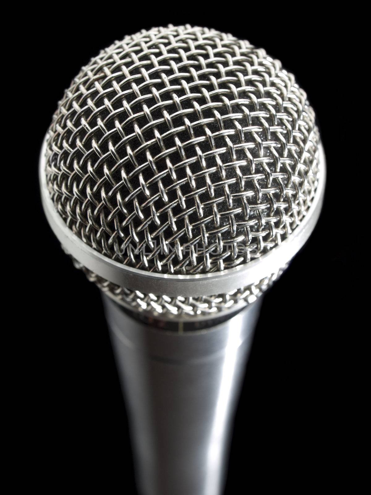 A dynamic microphone over a black background.