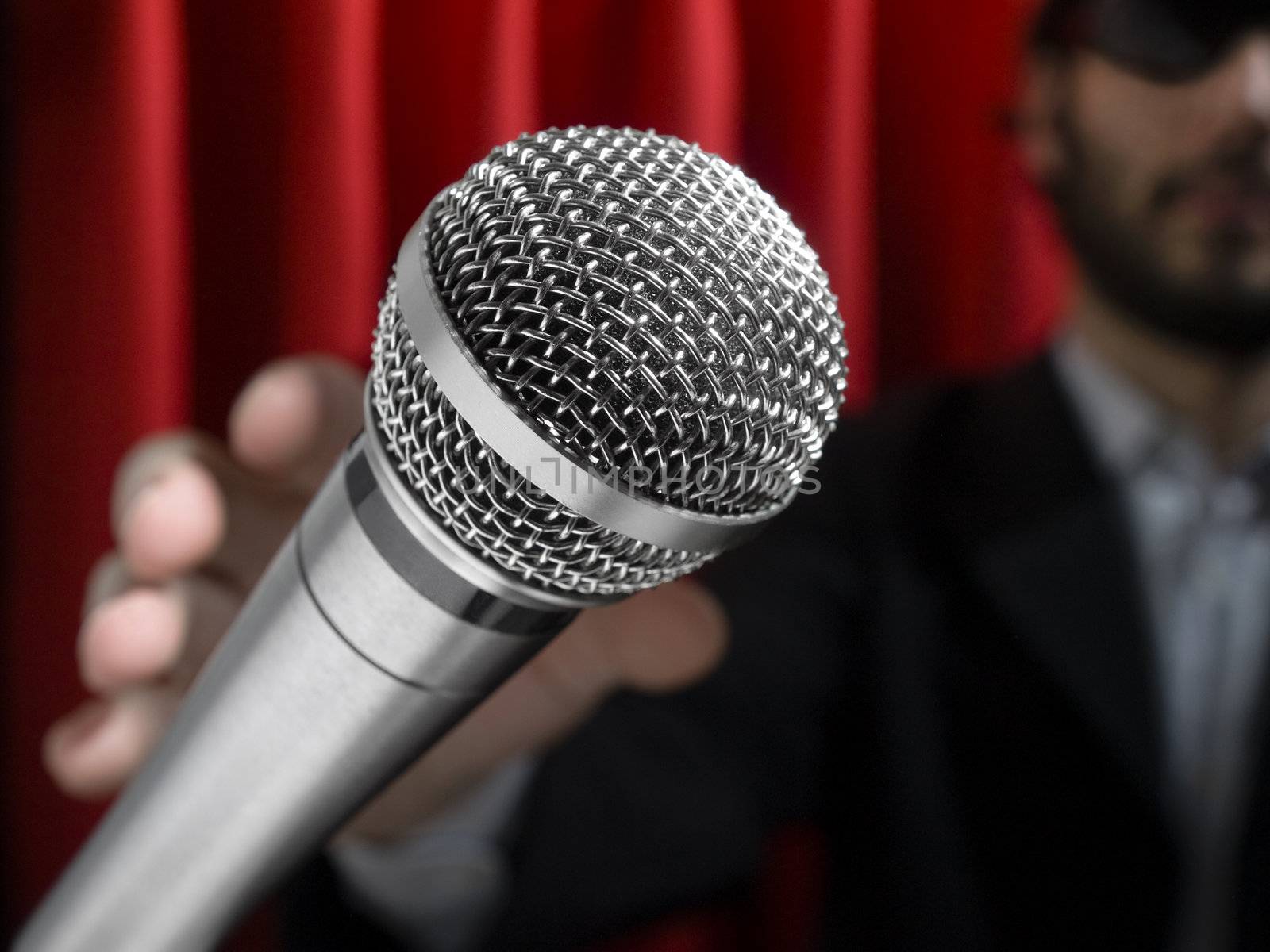 A youg man on stage about to grab a microphone.