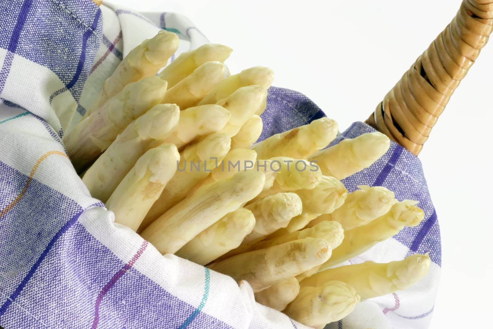 Fresh asparagus in a basket on bright background