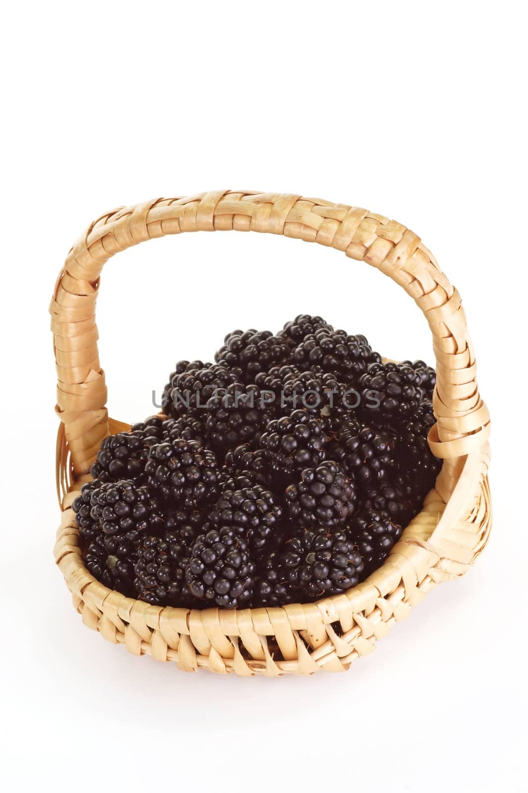 Fresh blackberries in a basket on bright background