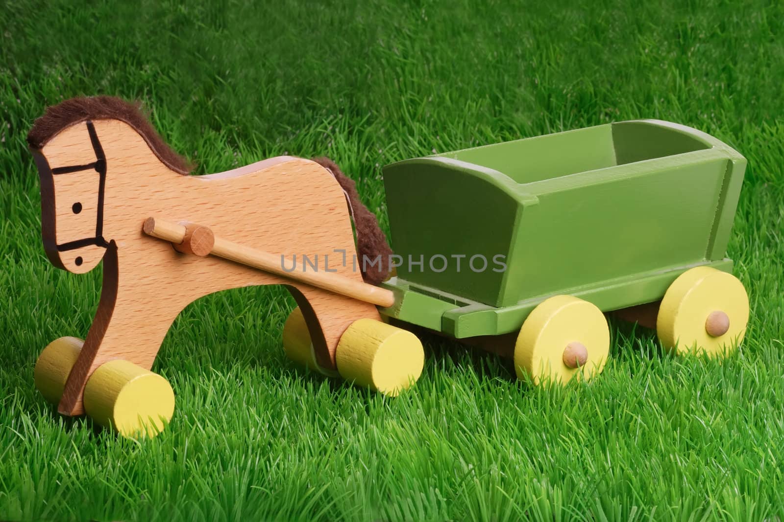 Horse wooden toy on green grass background