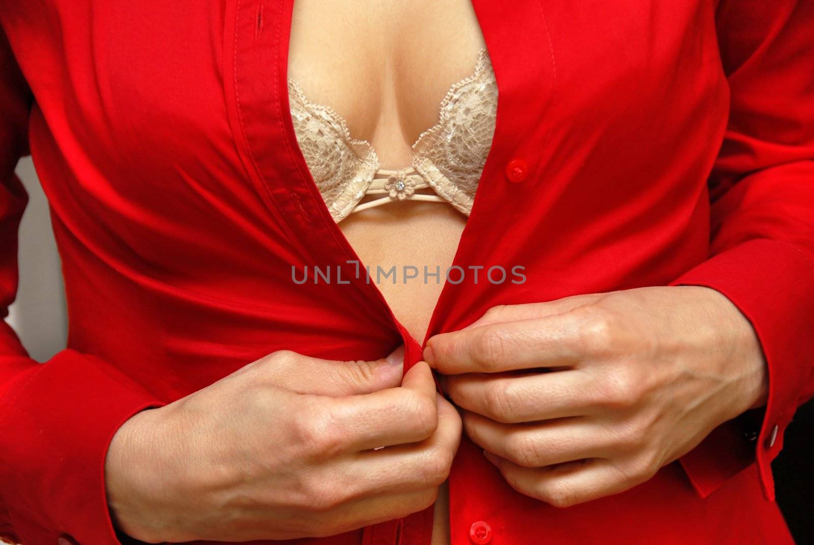 young woman in sexy beige brad putting on  her red shirt