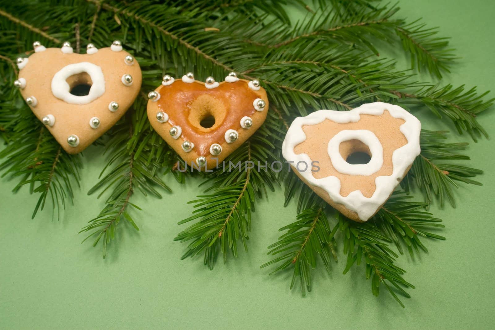 Three heart gingerbread cookies on fir branch