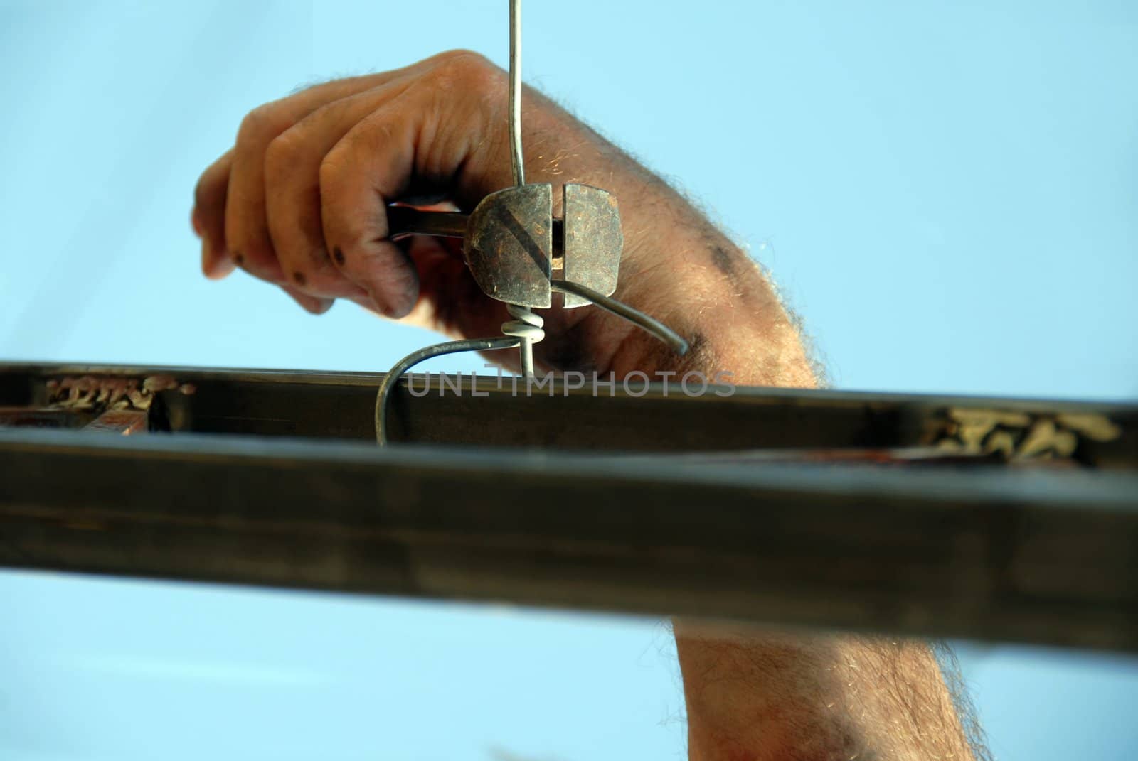 worker dirty hand with nippers and wire