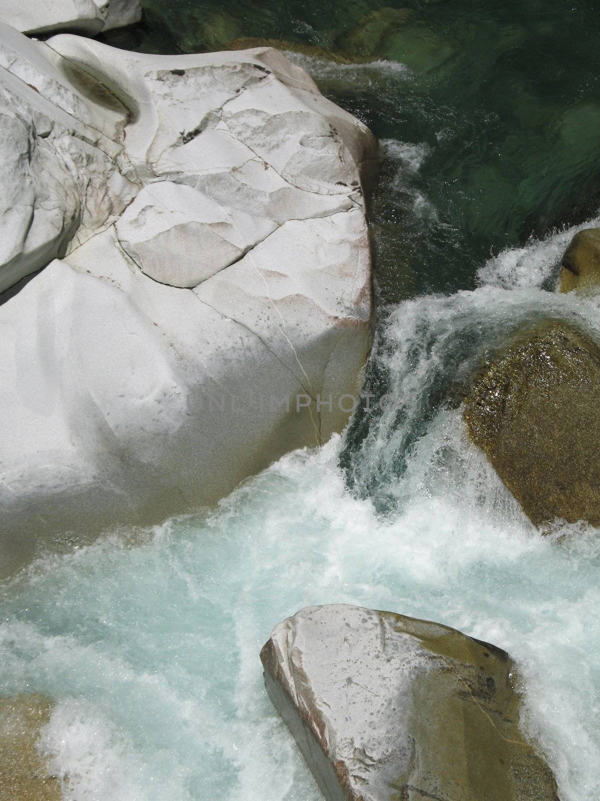 grey polished rocks and green river water