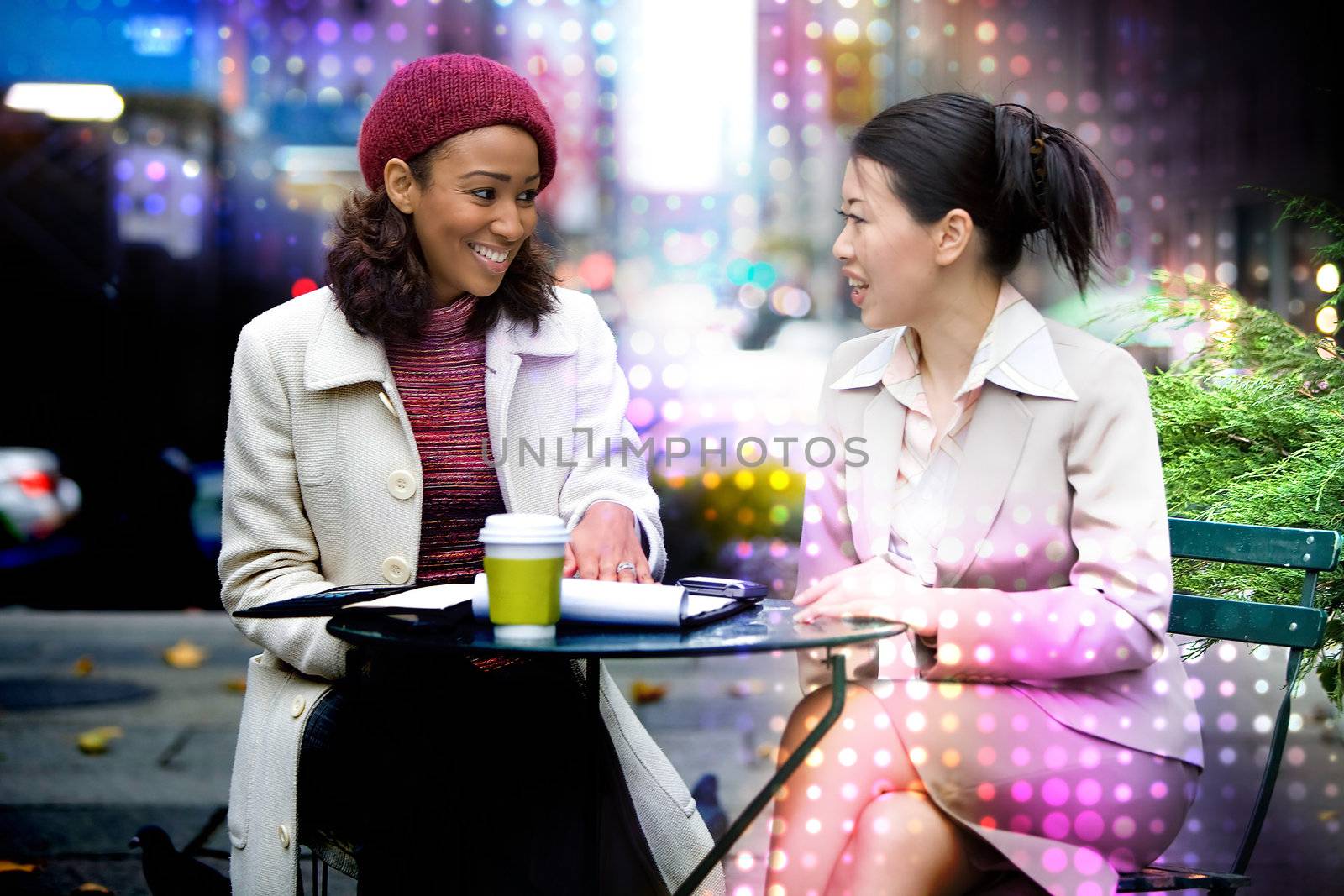 Two business women having a casual meeting or discussion in the city with an abstract glowing halftone circles effect.