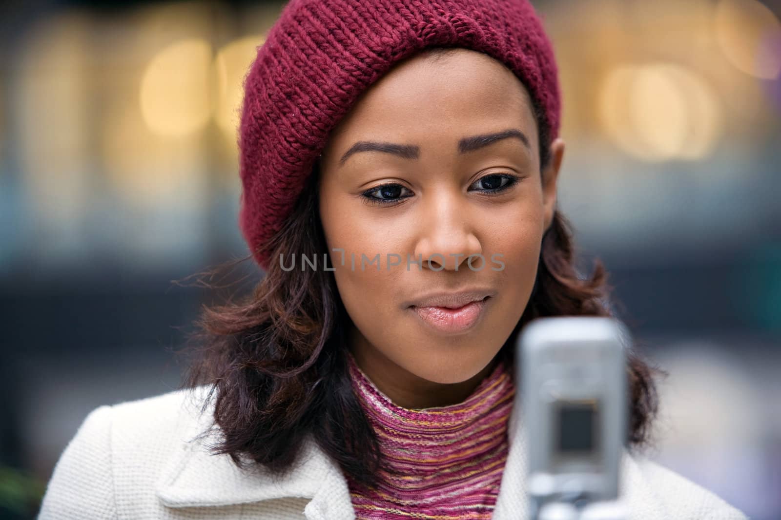 A young woman text messaging or checking something on her wireless phone.