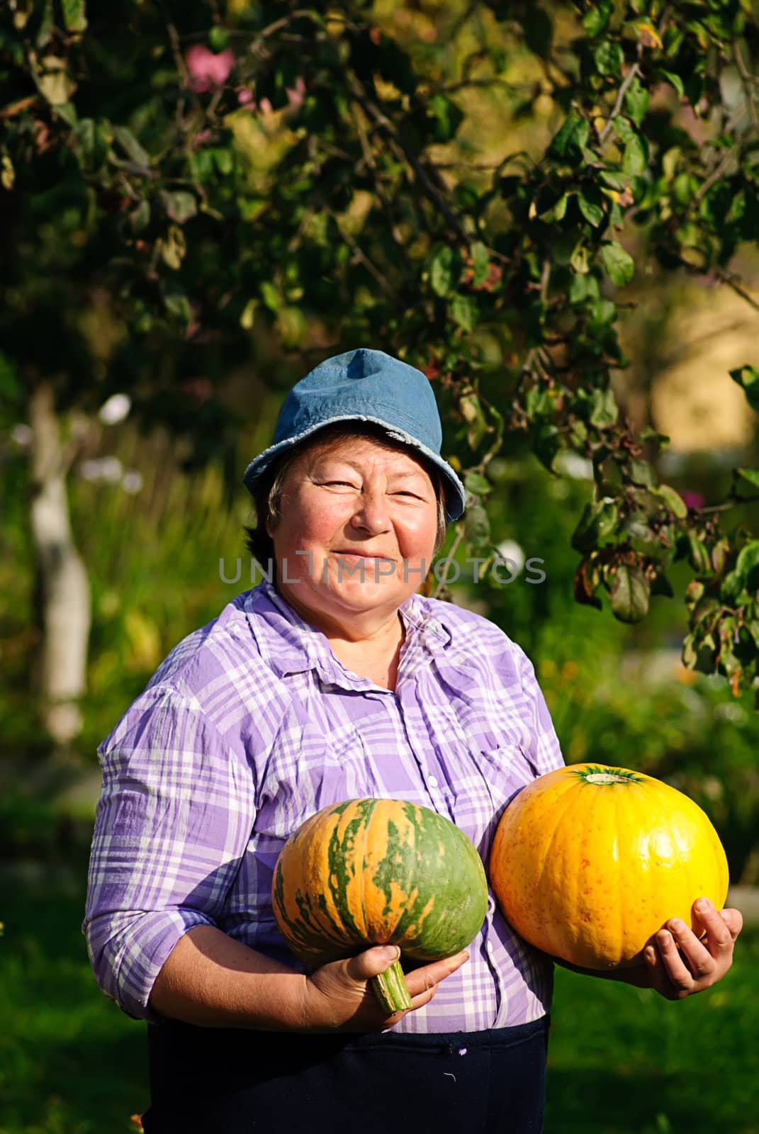 happy woman and two ripe pumpkin in garden