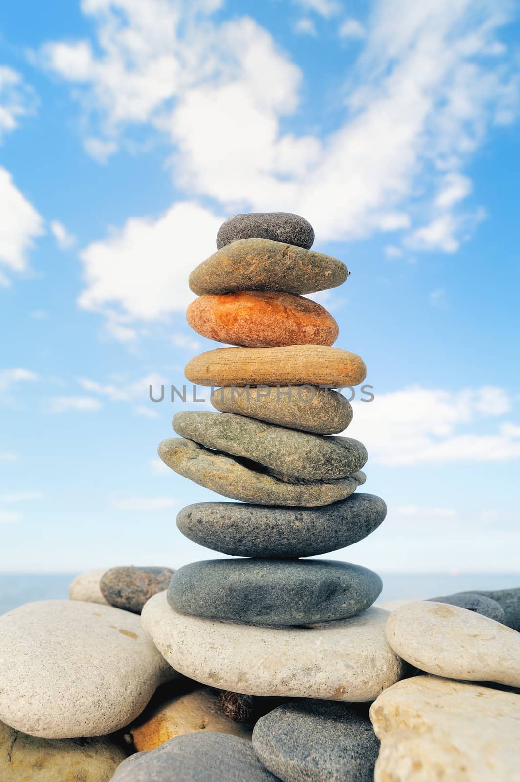 Stack of pebbles of the different colors on the shore