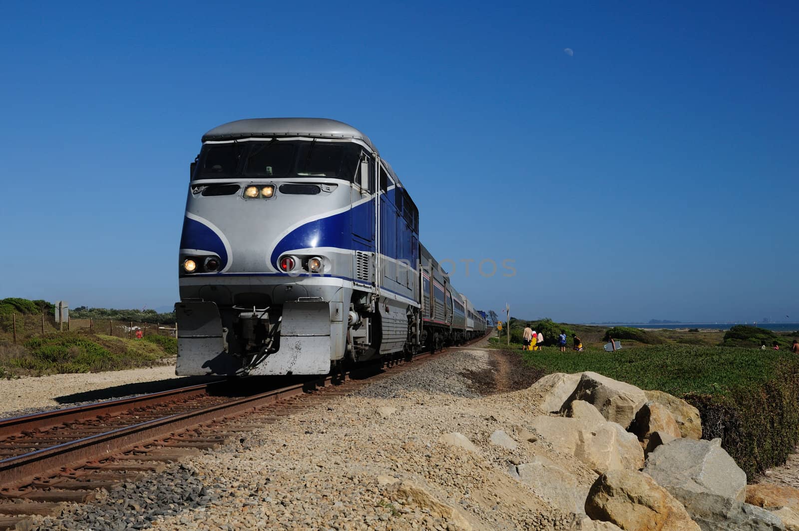 train rushes along tracks on the California coast