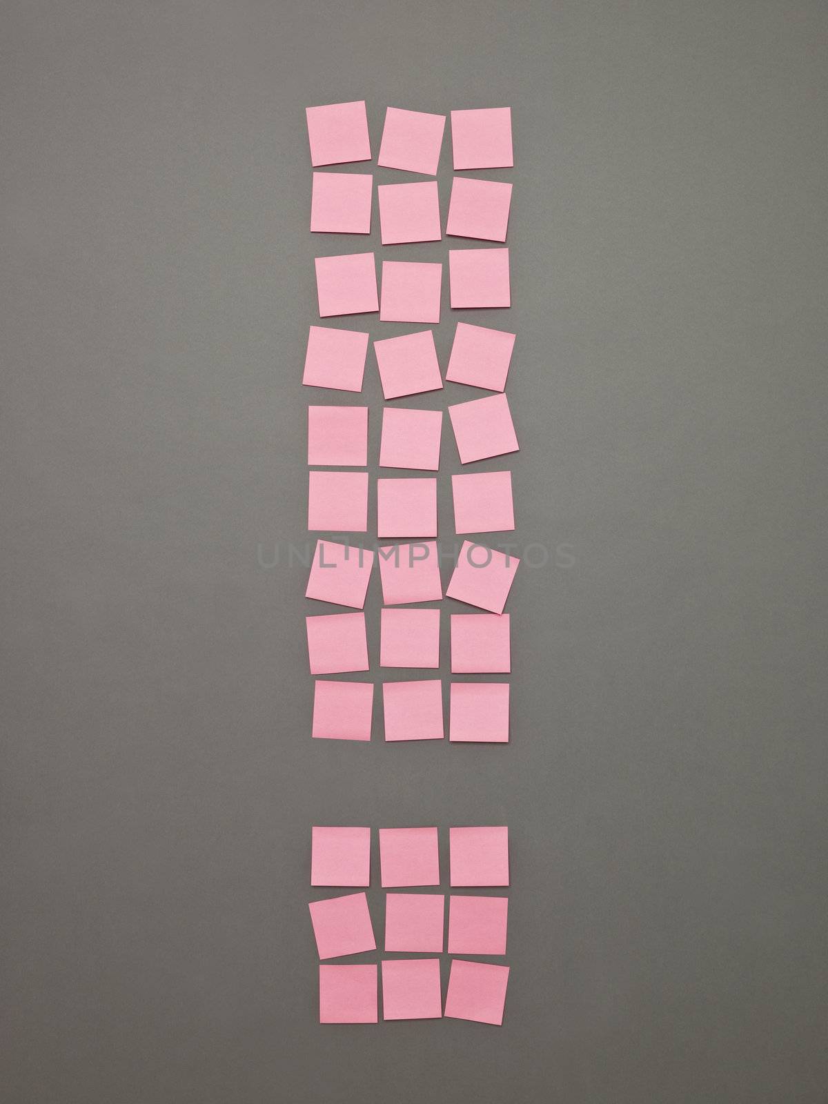 Exclamtion Mark made of Pink Adhesive Notes on grey background