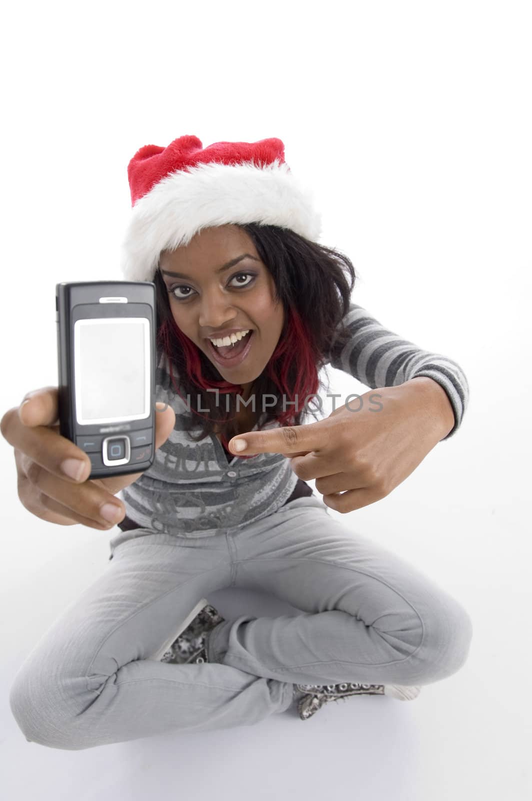 sitting girl indicating cell phone on an isolated background