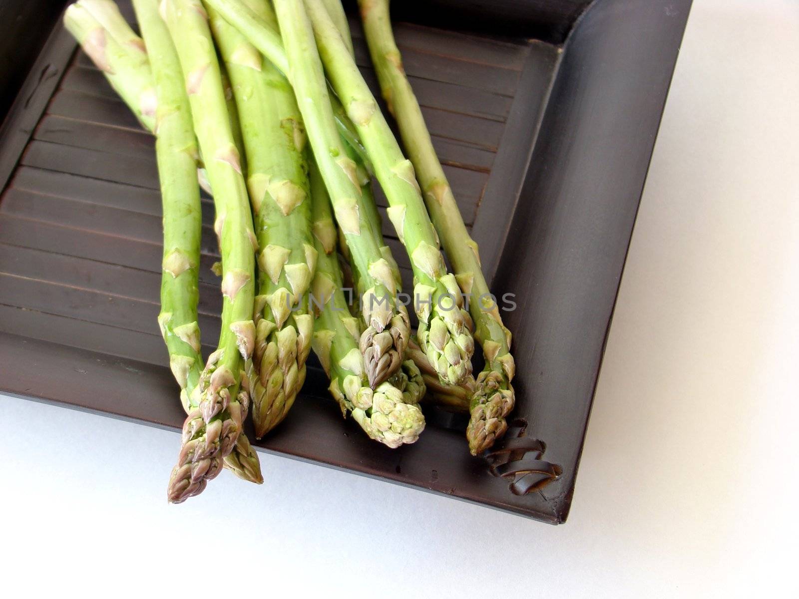 Asparagus on black plate by Flaps