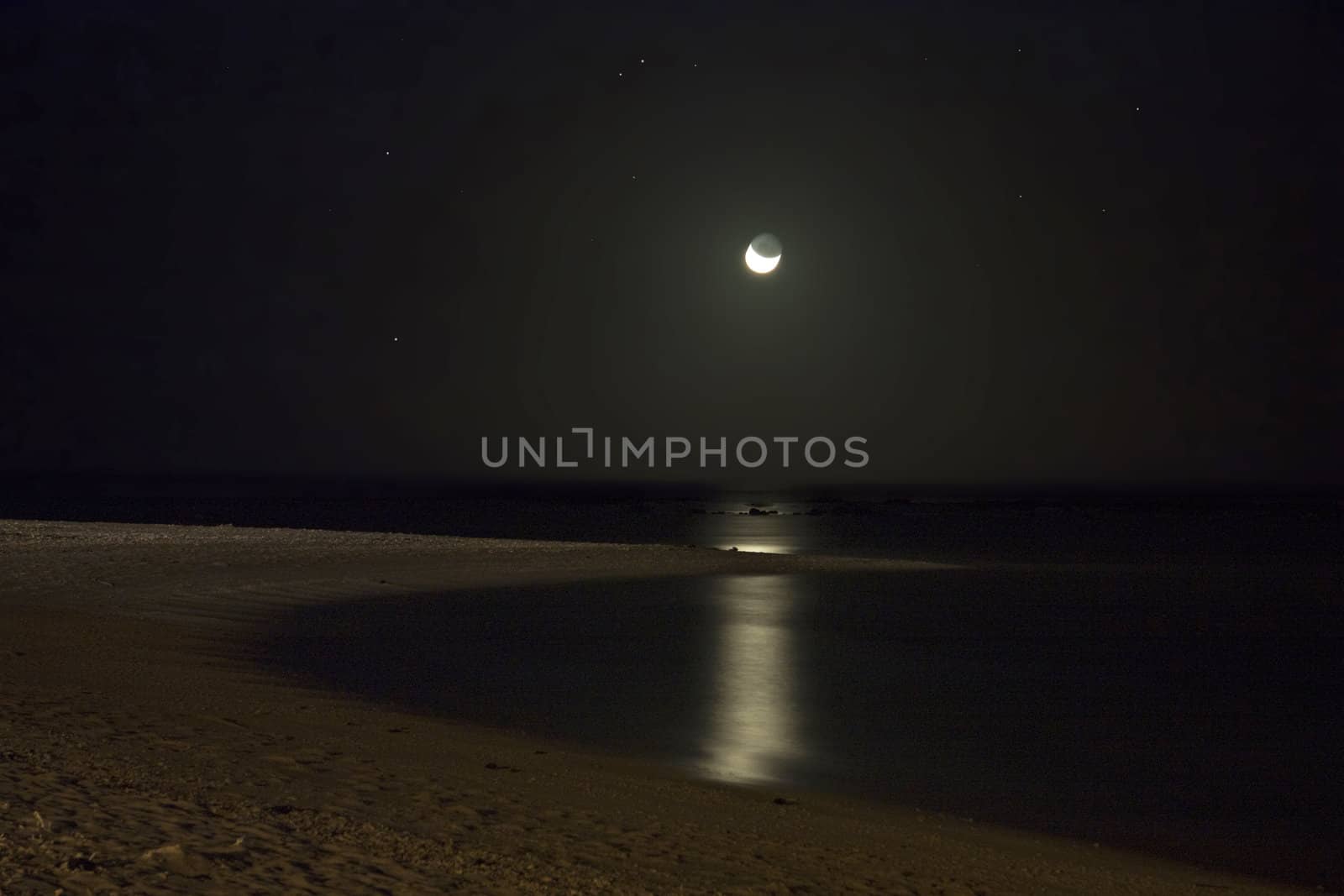 Moonlit beach at night, the moonlight dimly lighting the bay