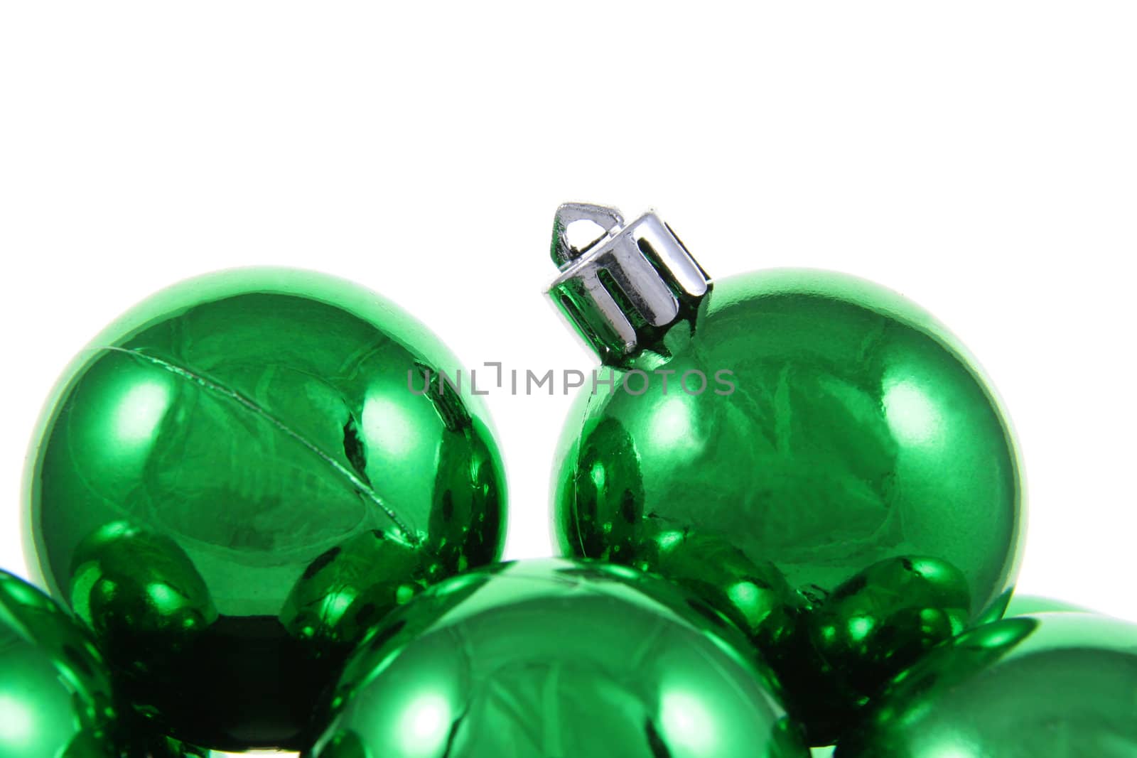 A bunch of green Christmas baubles against a white background.
