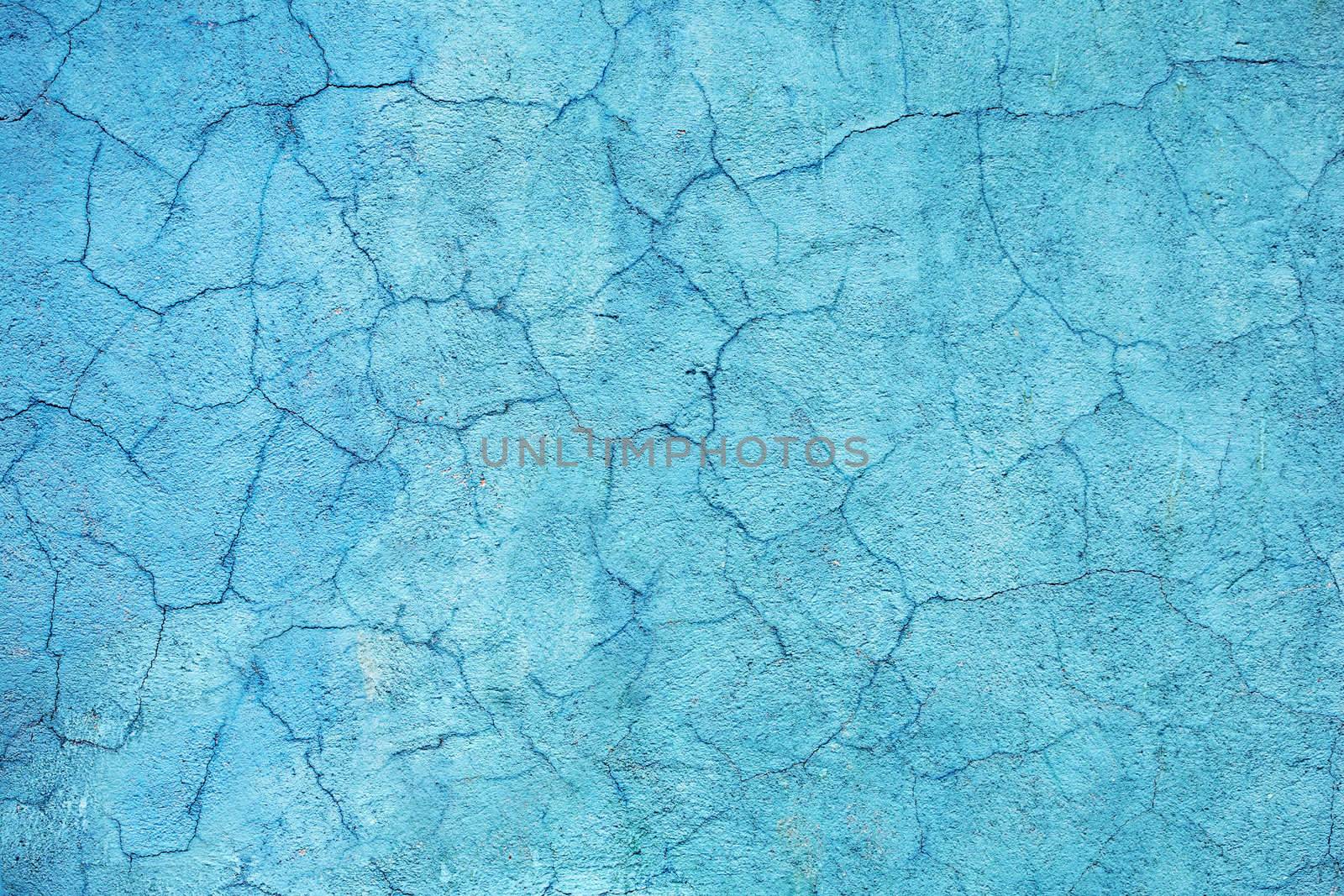Concrete walls are covered with blue paint with cracks
