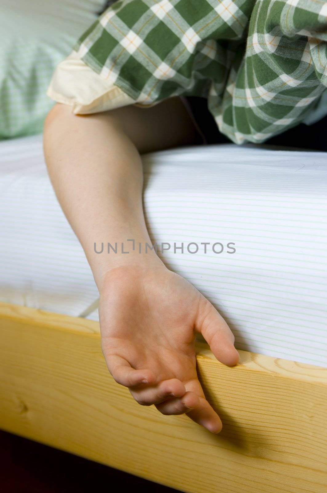 hand of a sleeping woman hanging from the bed