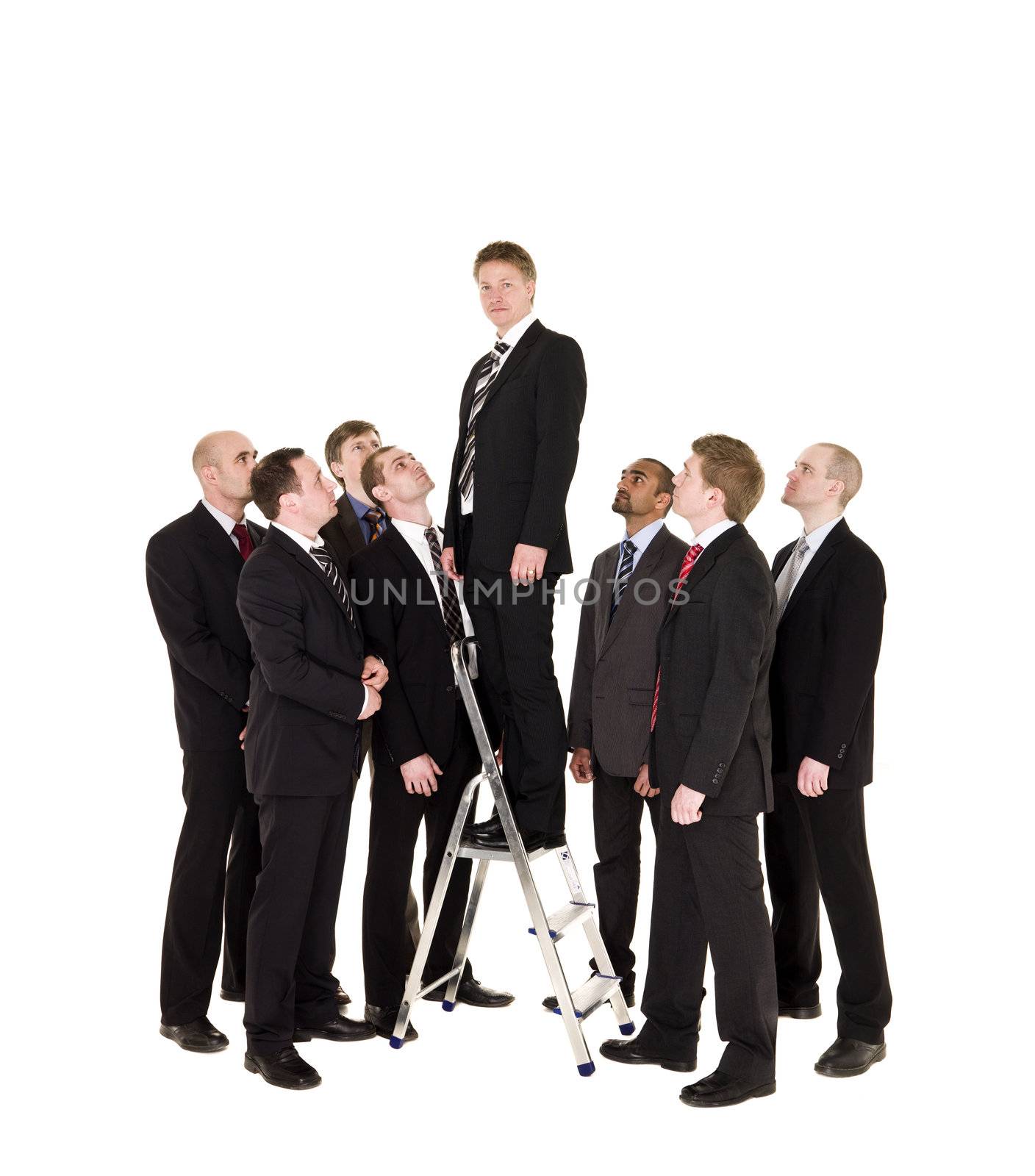 Manager standing on a step ladder with his business team around