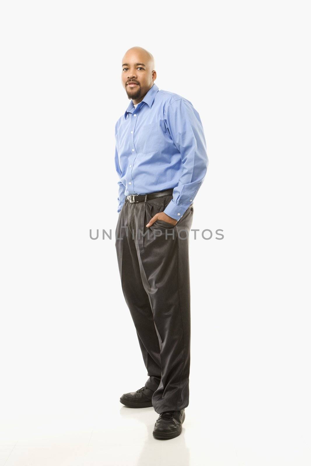 Portrait of African American man standing against white background.