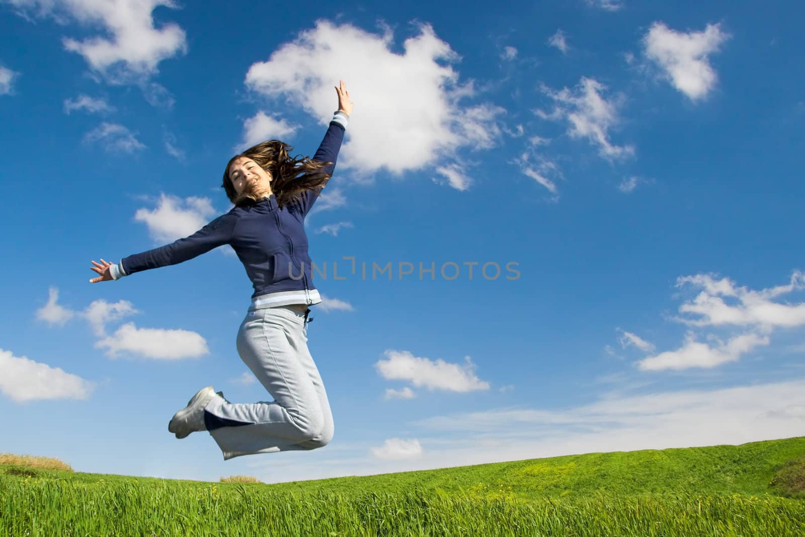 Young woman jumping in a green field
