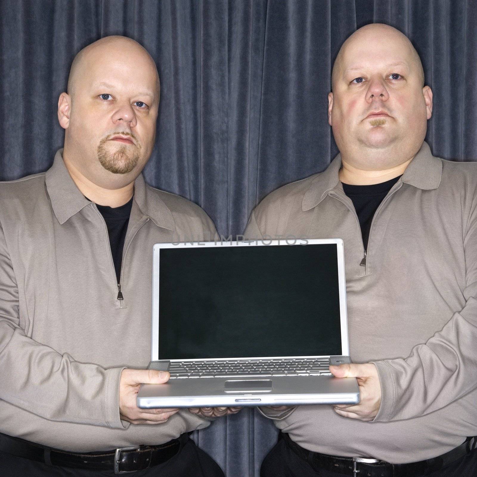 Twins with laptop. by iofoto