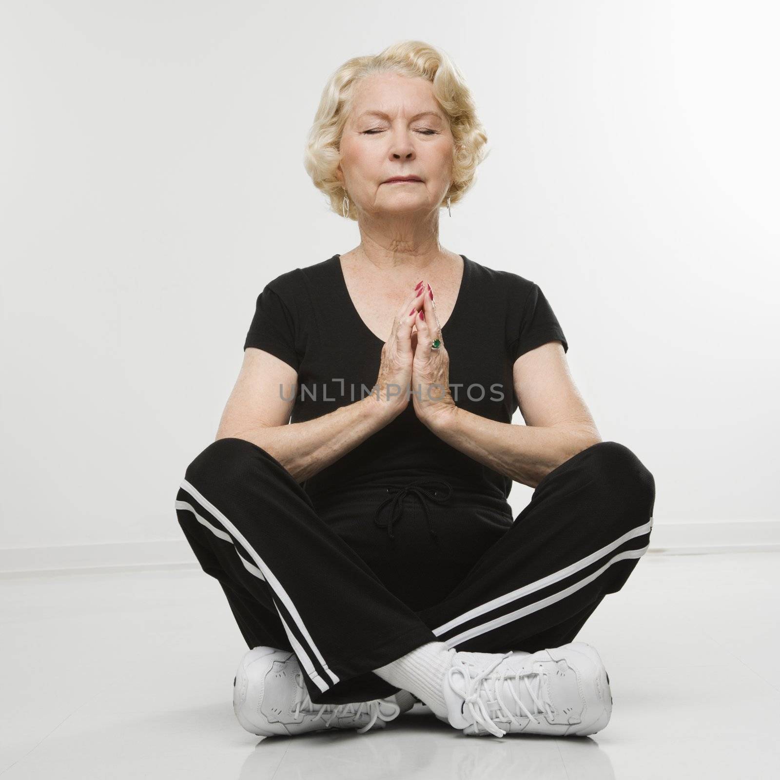 Senior woman meditating. by iofoto