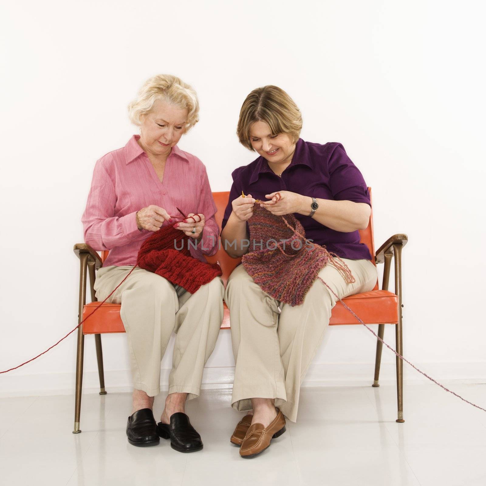 Two women knitting. by iofoto
