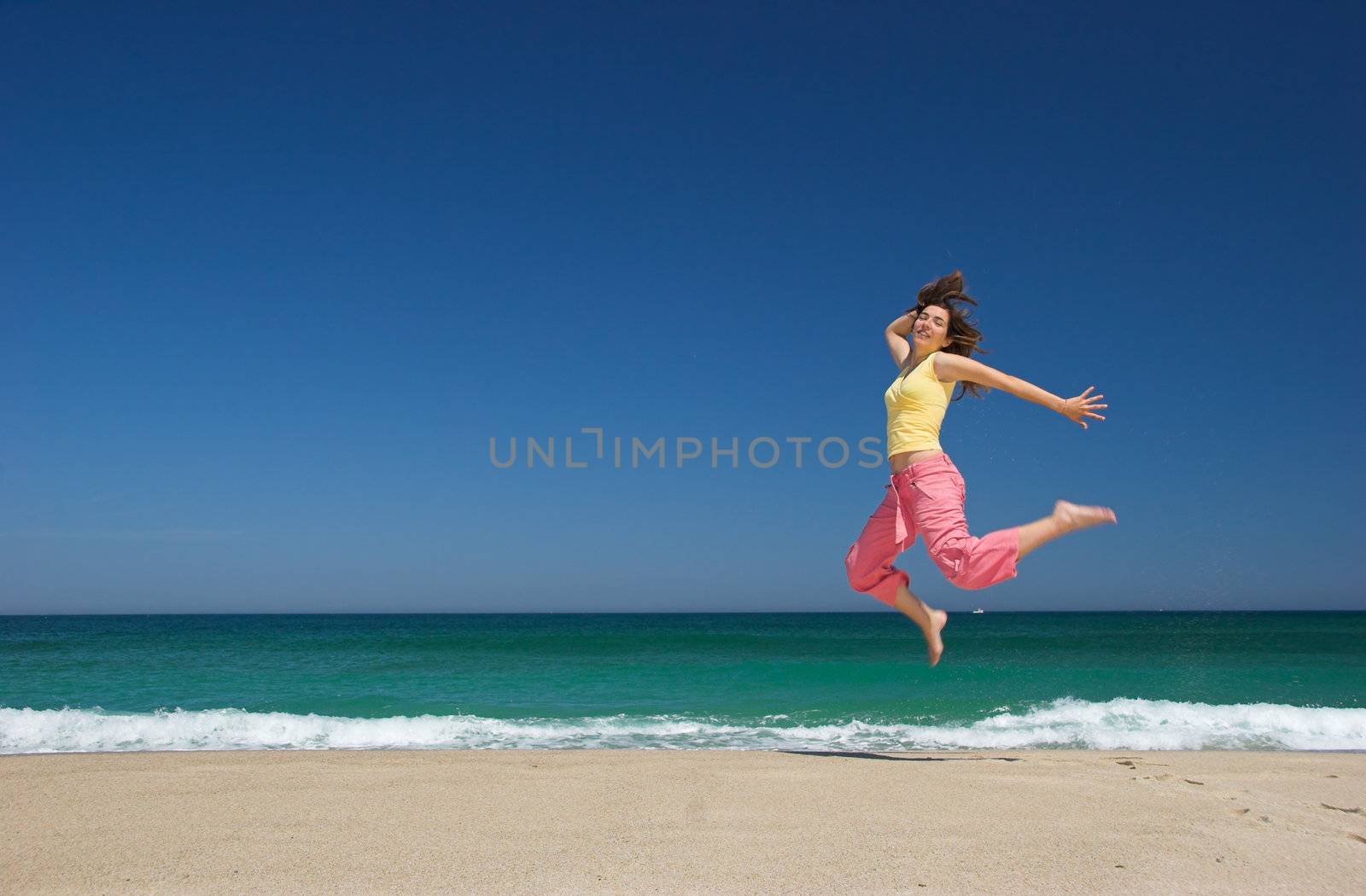 beautiful woman jumping in the beach