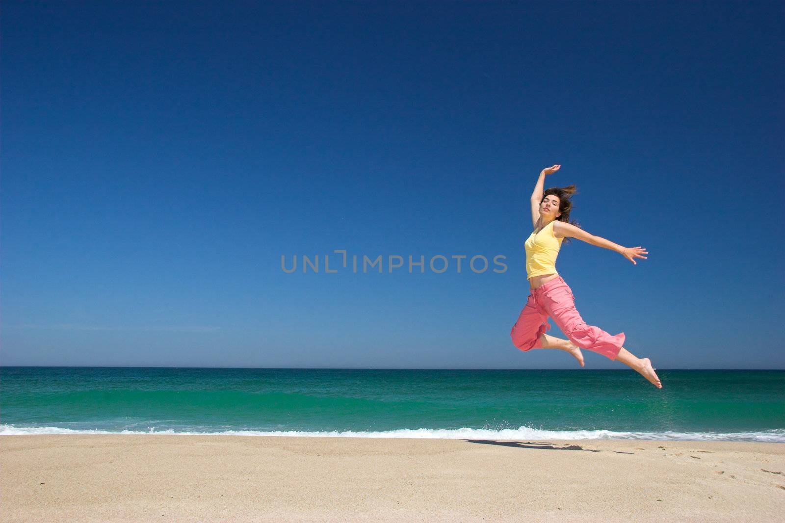 beautiful woman jumping in the beach by Iko