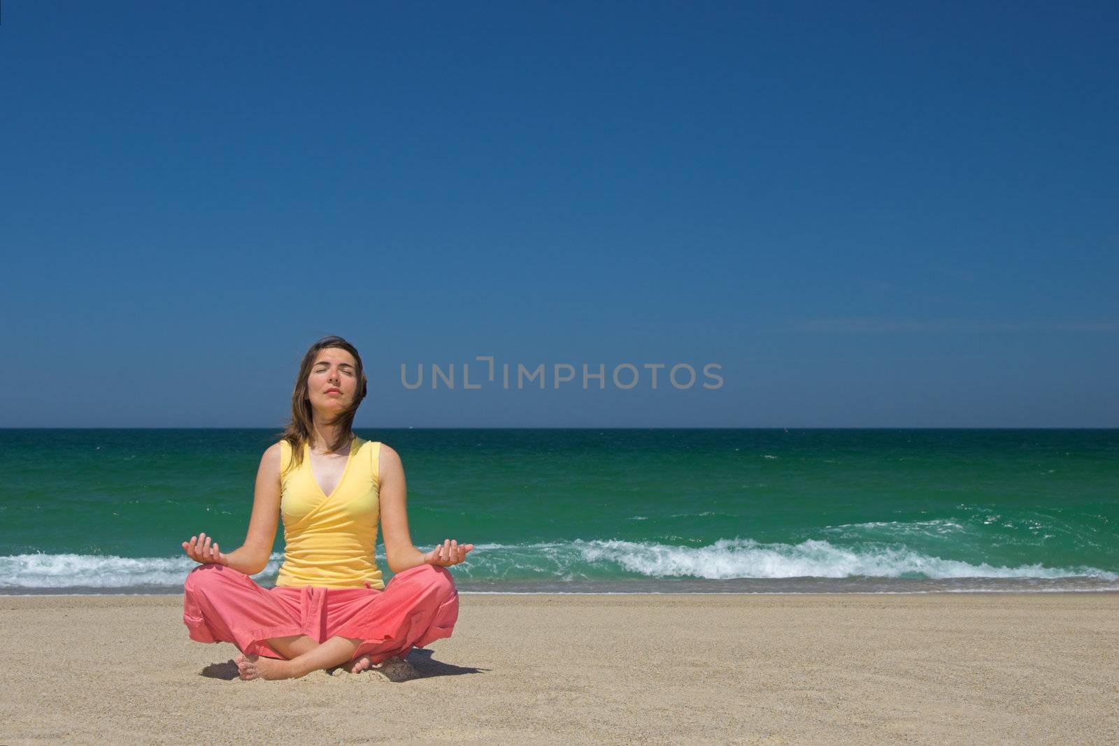 Woman making yoga in the bach by Iko