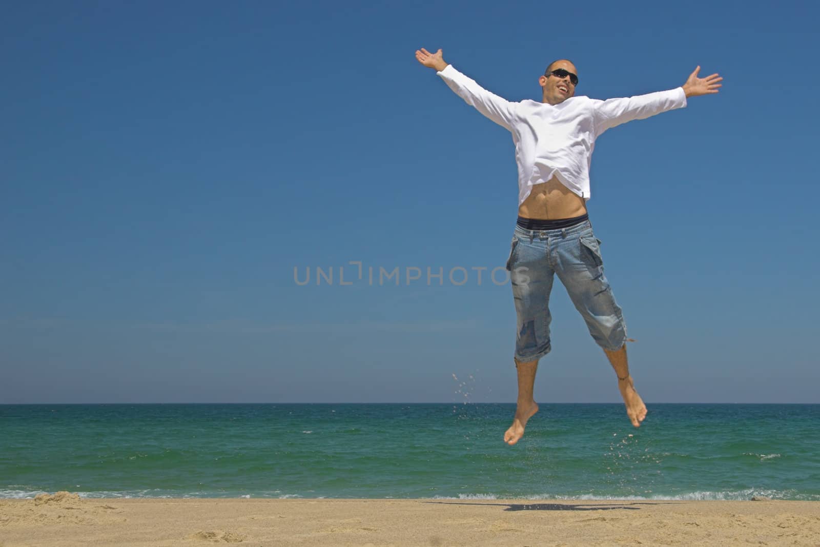 Man jumping on the beach by Iko