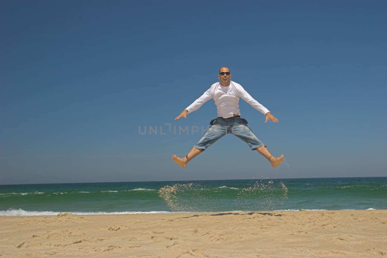 Man jumping on the beach by Iko