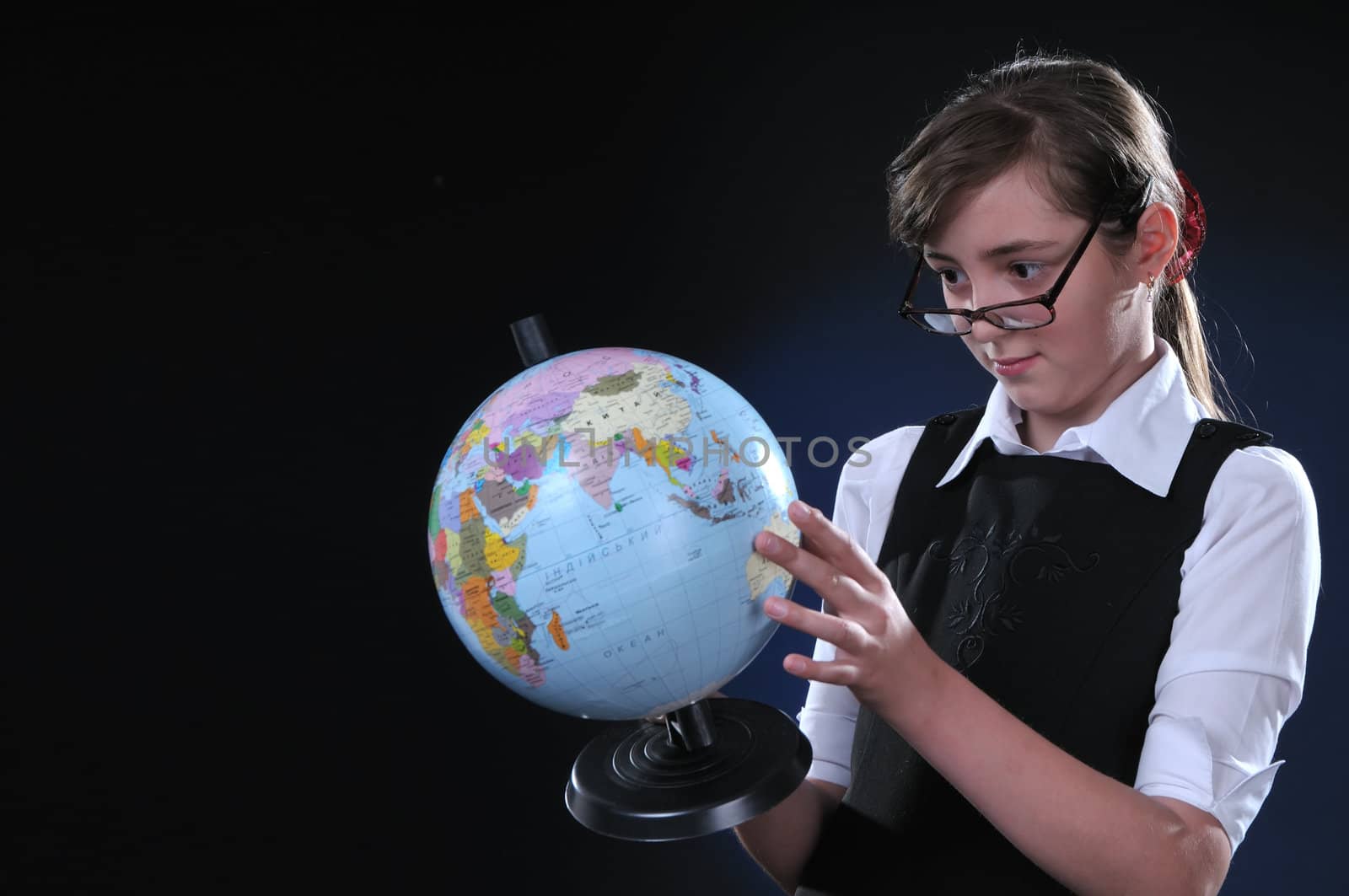 Schoolgirl of ten years in glasses gets on the hip student's globe