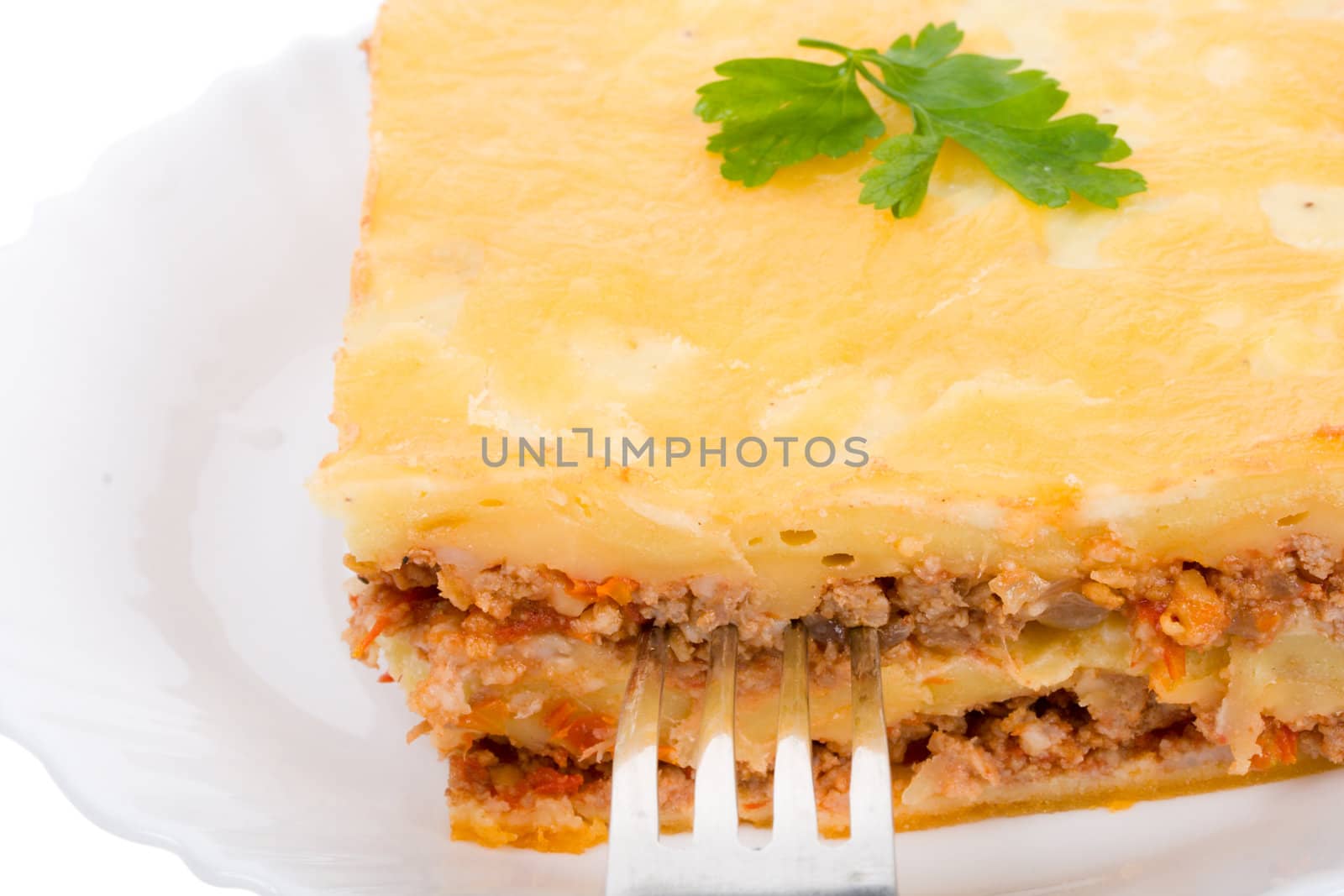 close-up lasagne on plate with fork, isolated on white