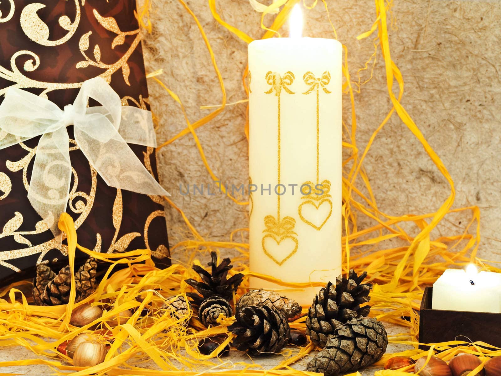 festive composition with gift, candle and cones against abstract background