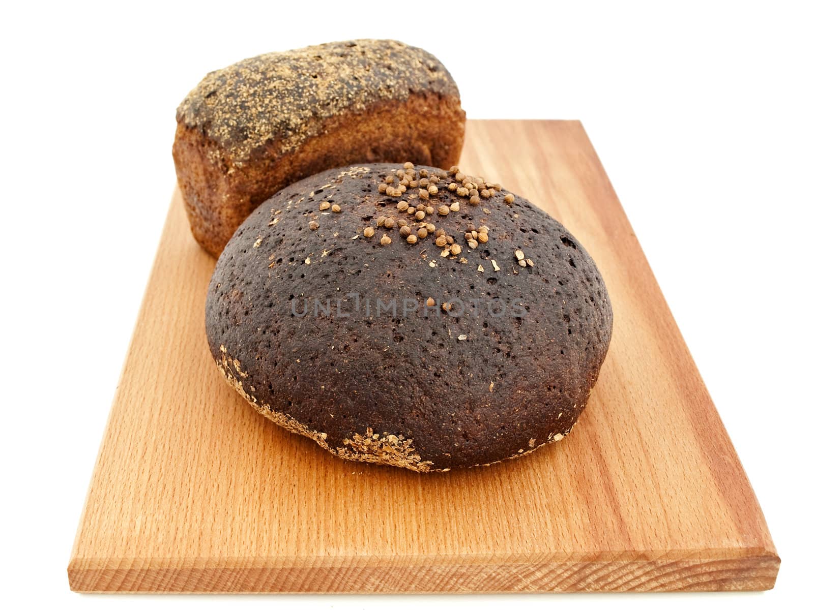 Two pieces of handmade bread at breadboard against white background