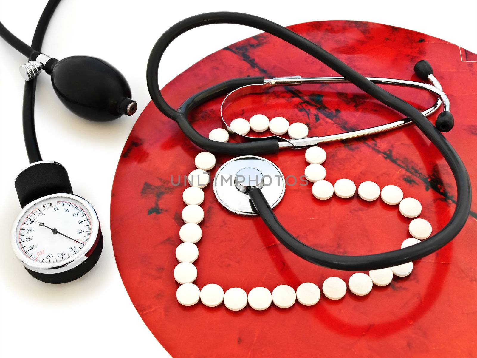 stethoscope and a white pills heart 