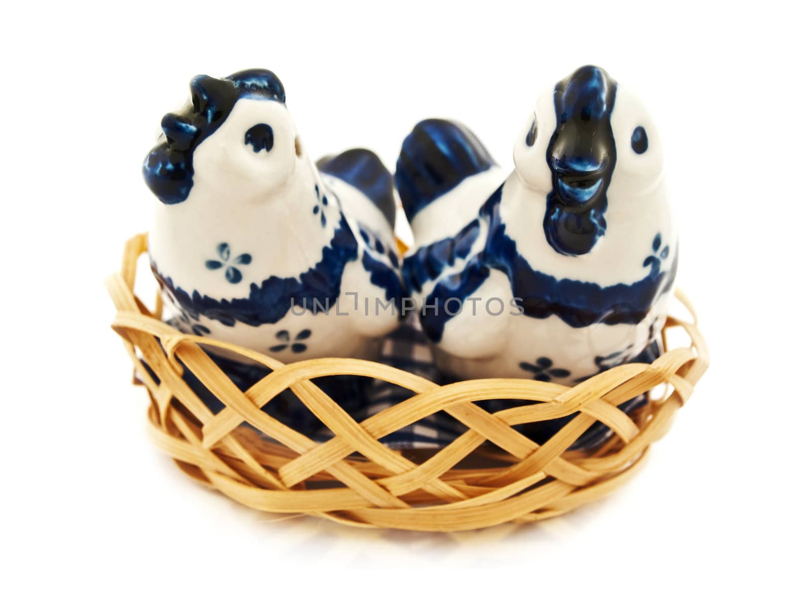 two porcelain chicken in wooden basket against white background