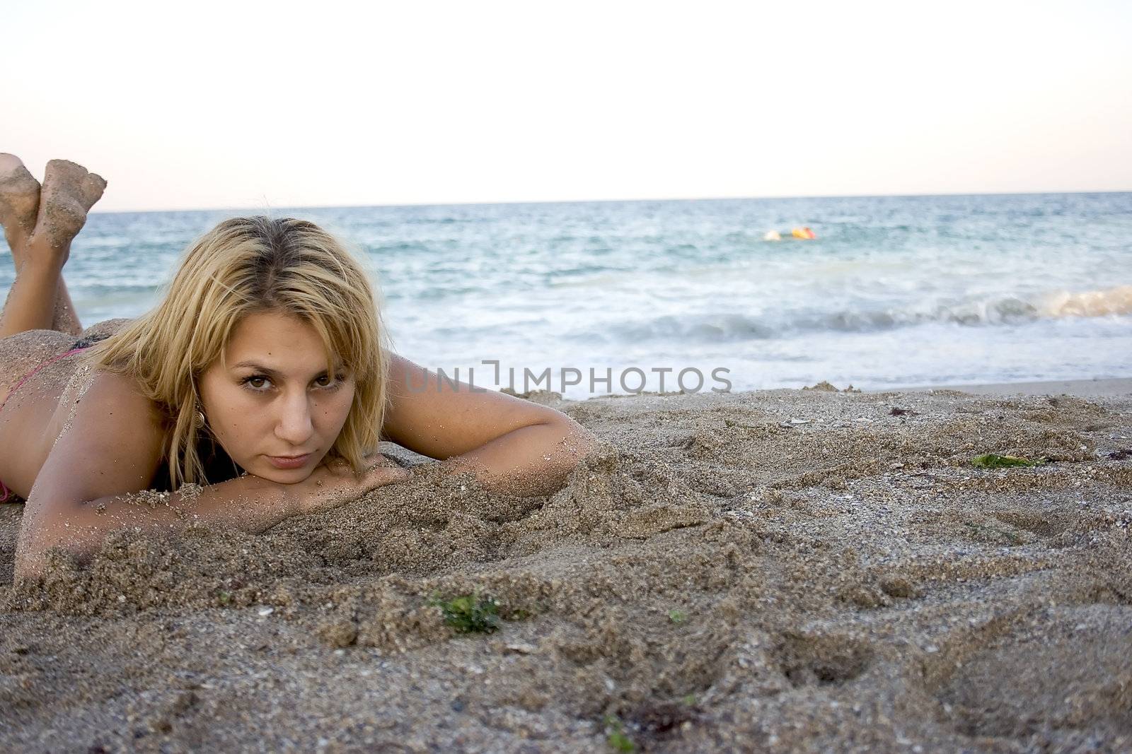 beautiful girl lying in sand near the sea