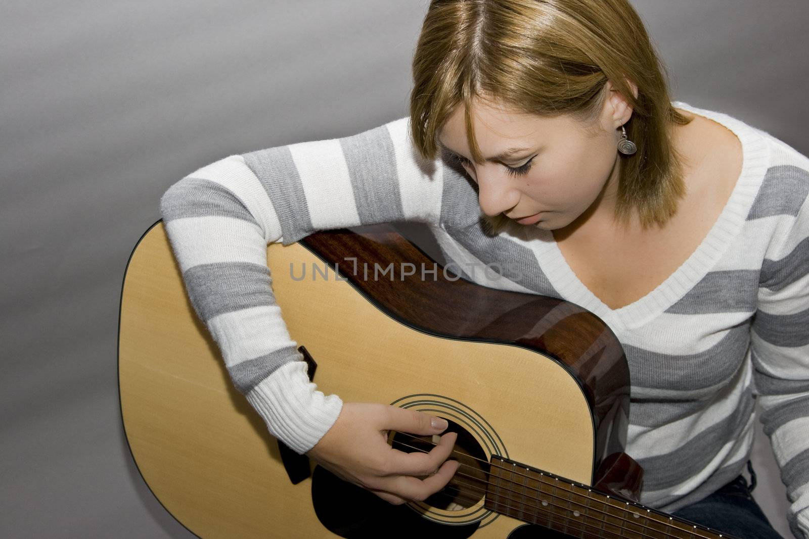 beautiful blonde girl playing at guitar